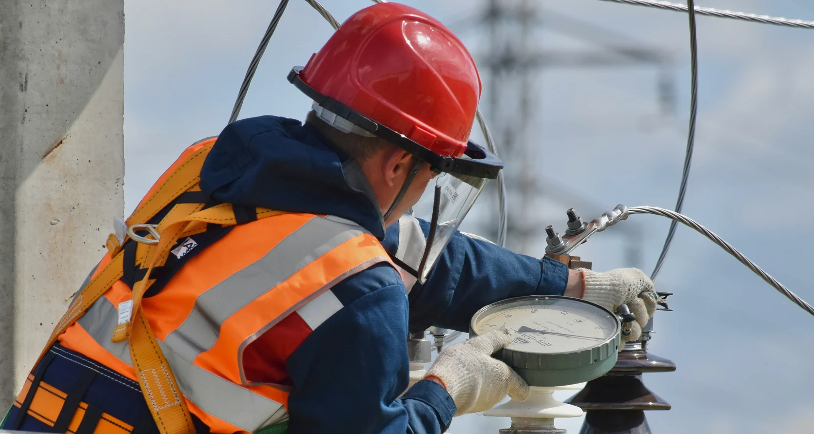 Field technician taking measurements on an overhead transmission line